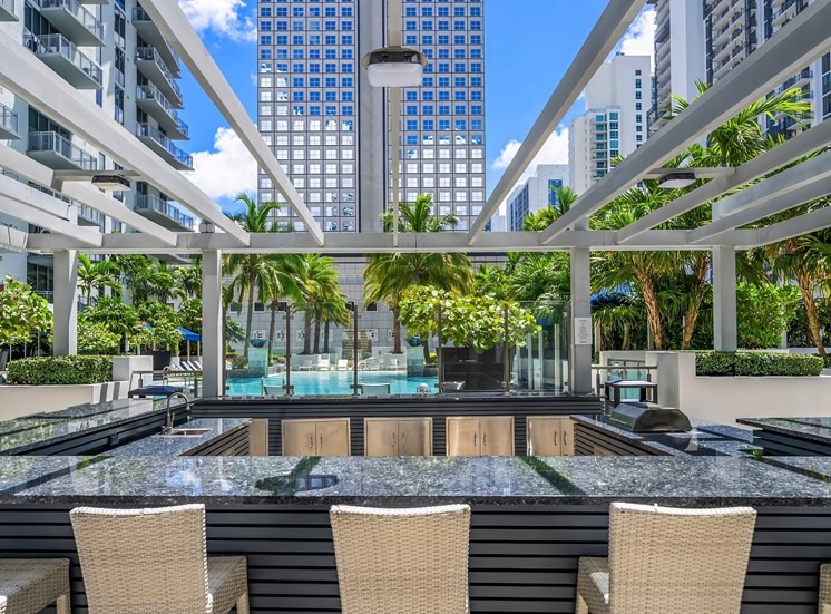 A pool area with chairs and a view of the city.